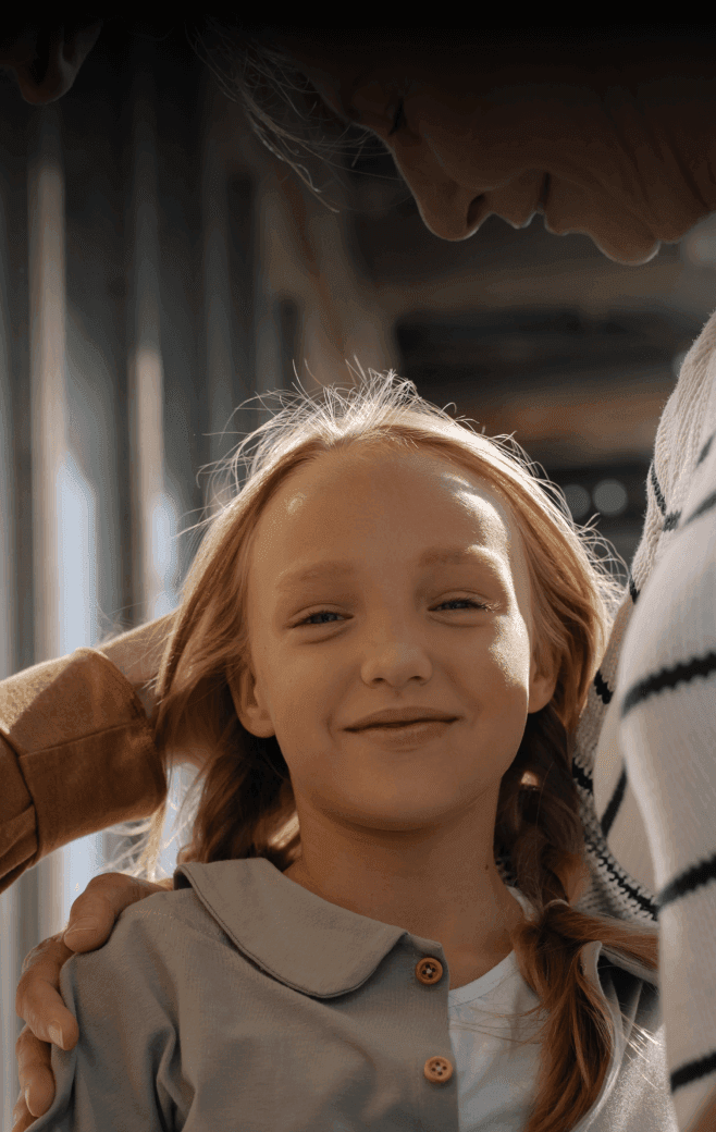 Smiling young girl standing between her grandparents.